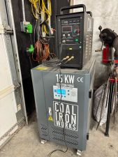 The induction forge on its rolling cart (power supply, control panel, coil, and chiller)